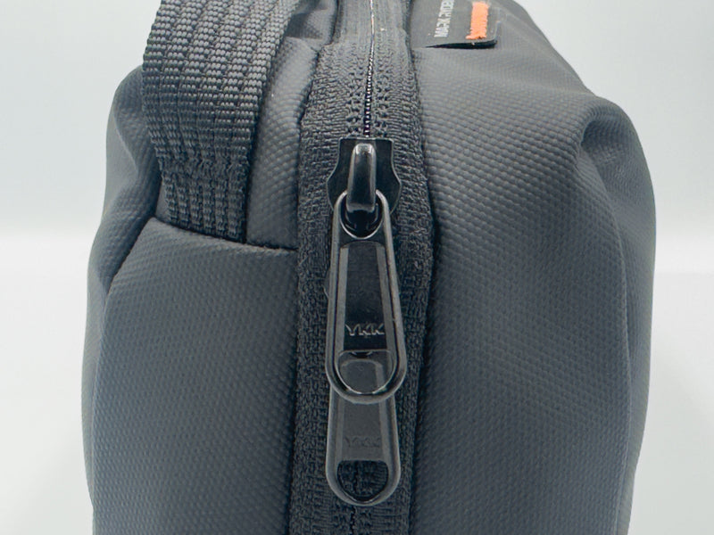 Close-up of black water-resistant ESSENTIA Bag with YKK zipper for organizing tech and travel essentials